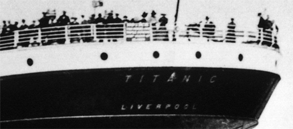 Emigrants stand at the stern rail of Titanic.